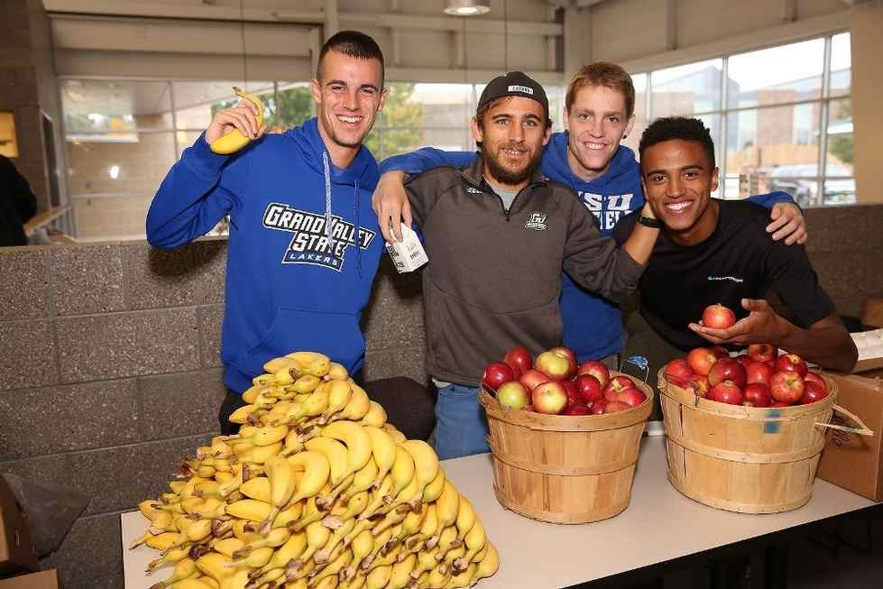 Four young men posing with fruit